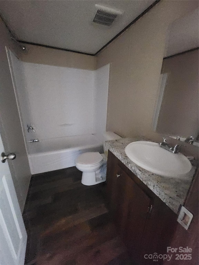 full bathroom featuring vanity, bathtub / shower combination, hardwood / wood-style floors, and toilet