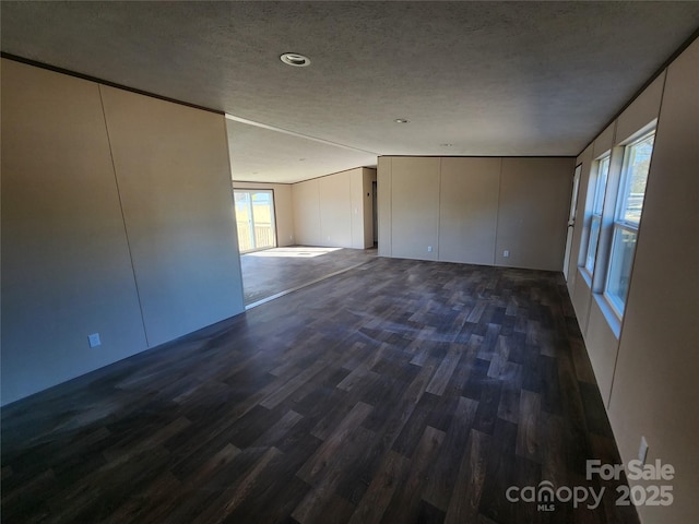 empty room featuring dark wood-type flooring and a textured ceiling