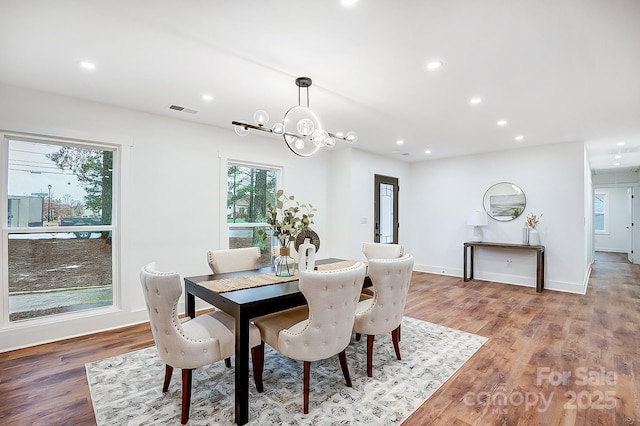 dining area with light hardwood / wood-style flooring and a chandelier