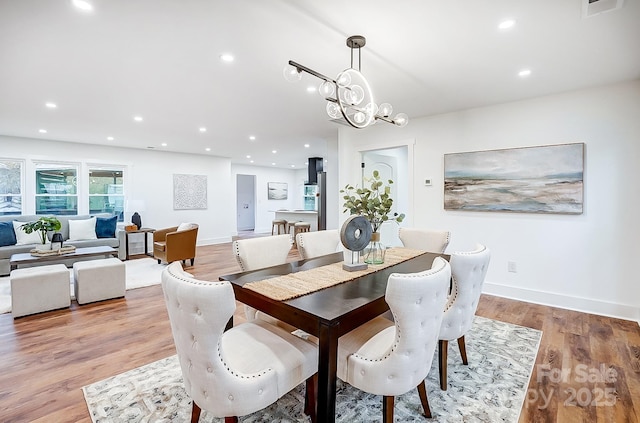 dining area featuring a notable chandelier and light hardwood / wood-style floors