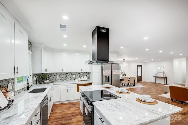 kitchen with sink, stainless steel appliances, a kitchen island, island exhaust hood, and white cabinets