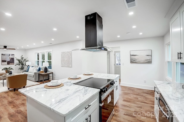 kitchen with range with electric stovetop, island exhaust hood, and white cabinets