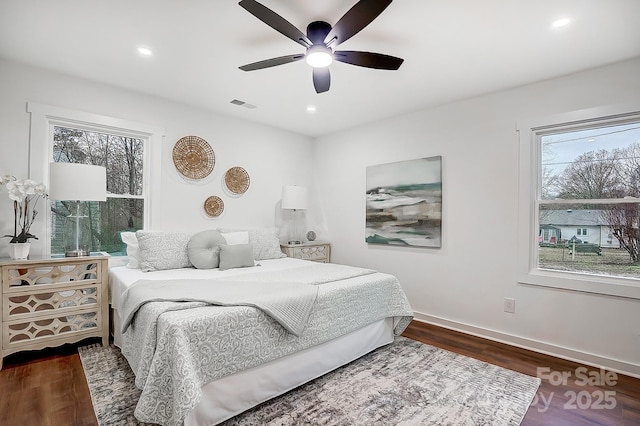 bedroom with multiple windows, ceiling fan, and dark wood-type flooring