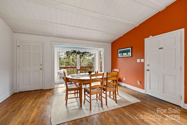 dining area with lofted ceiling with beams, dark hardwood / wood-style floors, and wooden ceiling