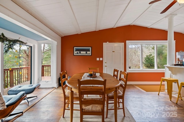 dining space with hardwood / wood-style flooring, plenty of natural light, and vaulted ceiling with beams