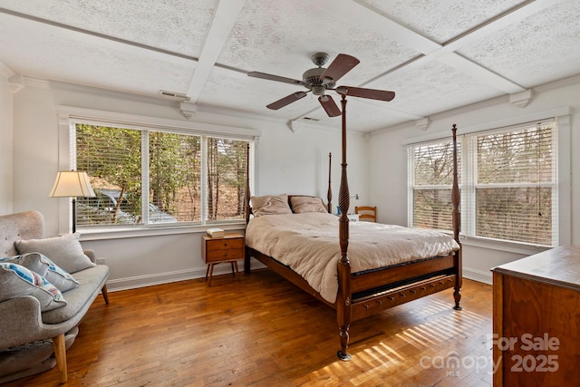 bedroom featuring ceiling fan, coffered ceiling, hardwood / wood-style floors, and multiple windows