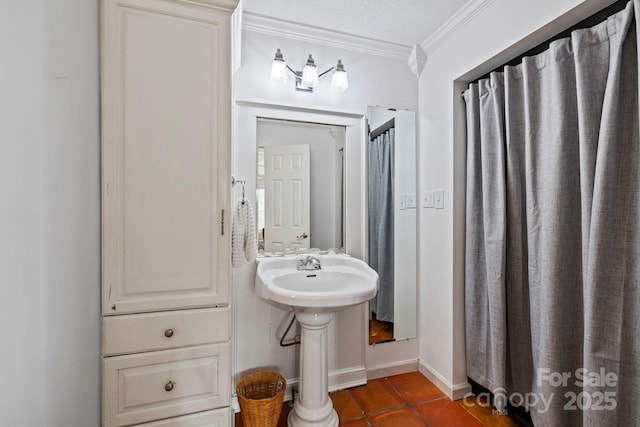 bathroom featuring crown molding, tile patterned floors, sink, and a textured ceiling