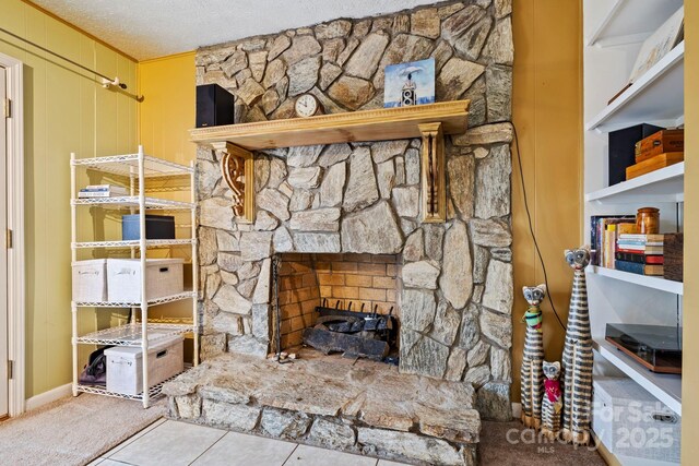 room details featuring carpet flooring, a fireplace, and a textured ceiling