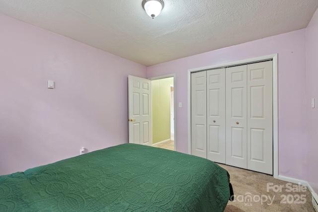 unfurnished bedroom with light carpet, a closet, and a textured ceiling