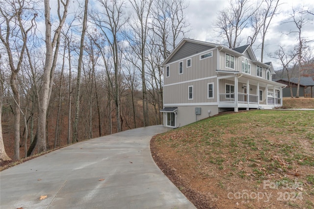 view of side of property with a lawn and covered porch