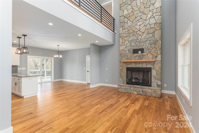 unfurnished living room featuring light hardwood / wood-style floors and a stone fireplace