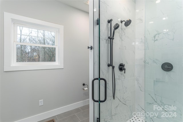 bathroom with tile patterned floors and a shower with door