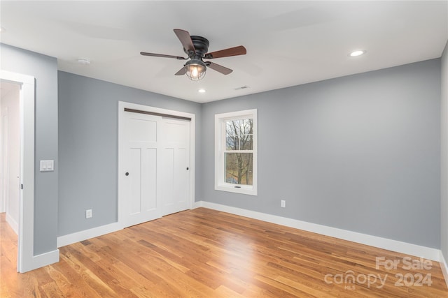 unfurnished bedroom featuring ceiling fan, a closet, and light hardwood / wood-style floors