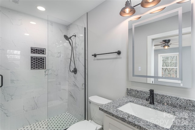 bathroom with ceiling fan, toilet, tiled shower, and vanity