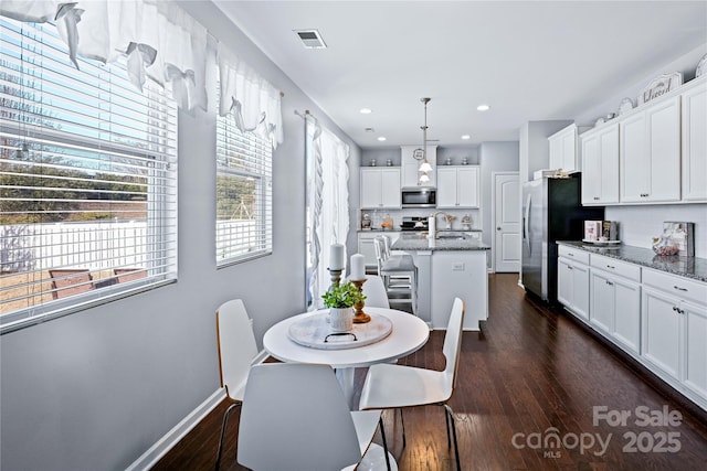 dining space with dark hardwood / wood-style flooring and sink