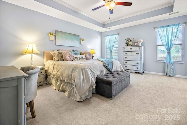 carpeted bedroom with ceiling fan, ornamental molding, and a raised ceiling