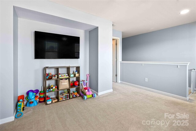 recreation room with radiator and light carpet