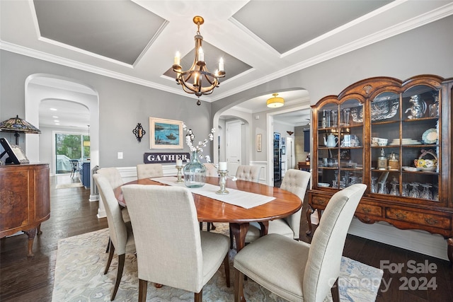 dining space featuring coffered ceiling, dark hardwood / wood-style floors, ornamental molding, and an inviting chandelier