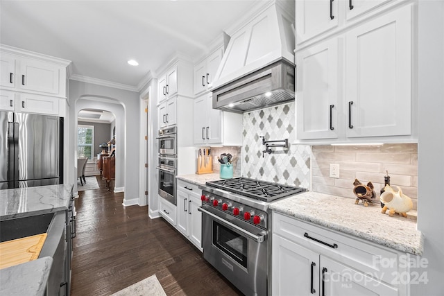 kitchen featuring ornamental molding, white cabinets, custom exhaust hood, and appliances with stainless steel finishes