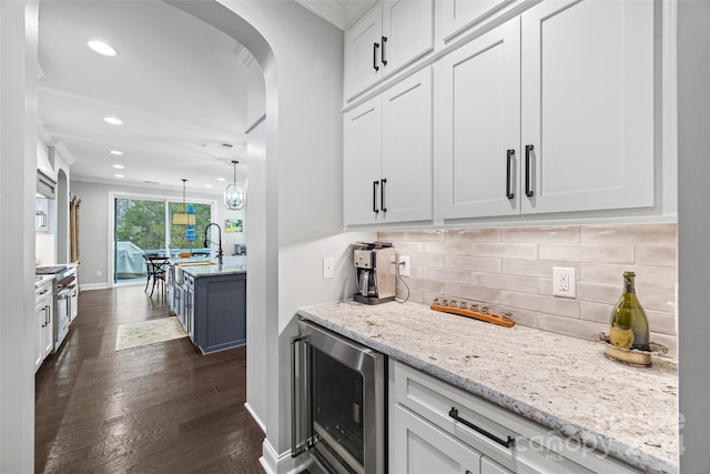 kitchen featuring decorative backsplash, beverage cooler, decorative light fixtures, dark hardwood / wood-style floors, and white cabinetry