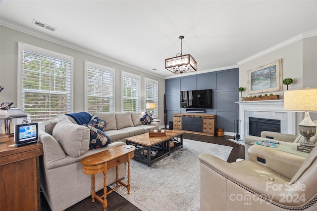 living room with a tile fireplace, wood-type flooring, ornamental molding, and a wealth of natural light