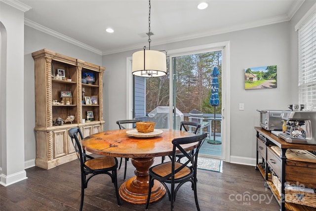 dining space featuring ornamental molding and dark wood-type flooring