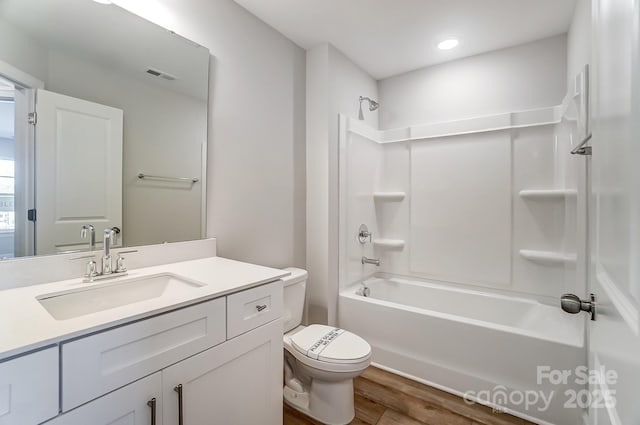 full bathroom with toilet, vanity,  shower combination, and hardwood / wood-style flooring