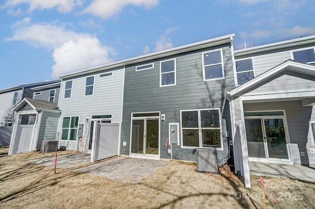 back of property with a patio area and central AC