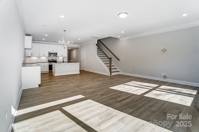 interior space with light wood-type flooring, an inviting chandelier, ornamental molding, and sink