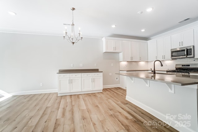 kitchen featuring white cabinets, sink, crown molding, and stainless steel appliances