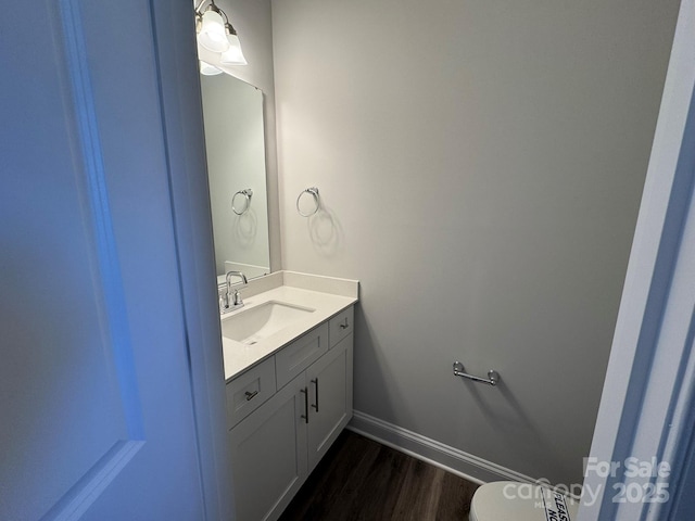 bathroom with hardwood / wood-style floors, vanity, and toilet