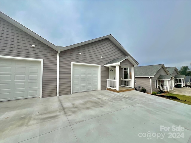 single story home featuring covered porch and a garage