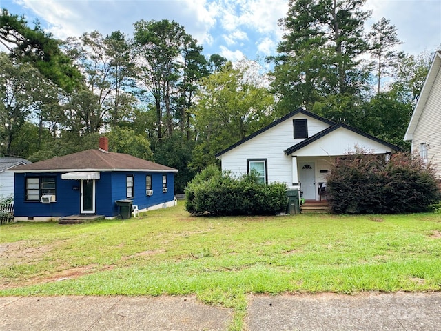 view of front of property featuring a front lawn and cooling unit