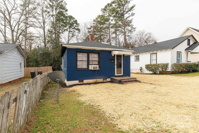 bungalow featuring a chimney, roof with shingles, crawl space, fence, and a front lawn