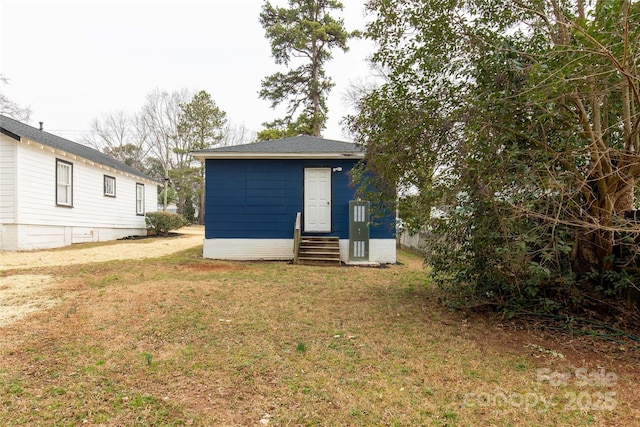 rear view of property with entry steps and a yard