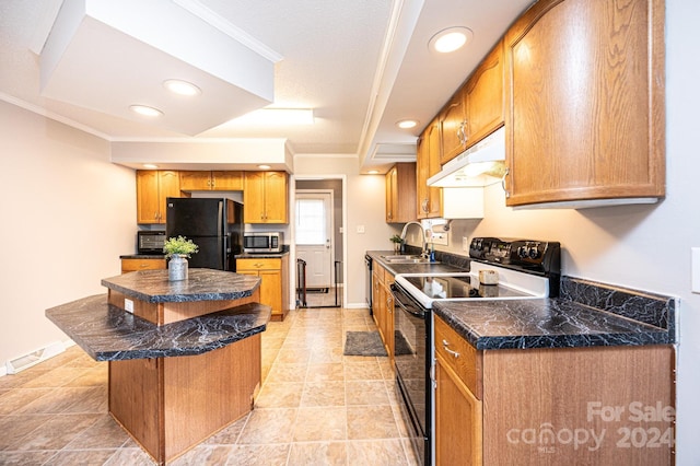 kitchen with a center island, black refrigerator, crown molding, sink, and range with electric stovetop