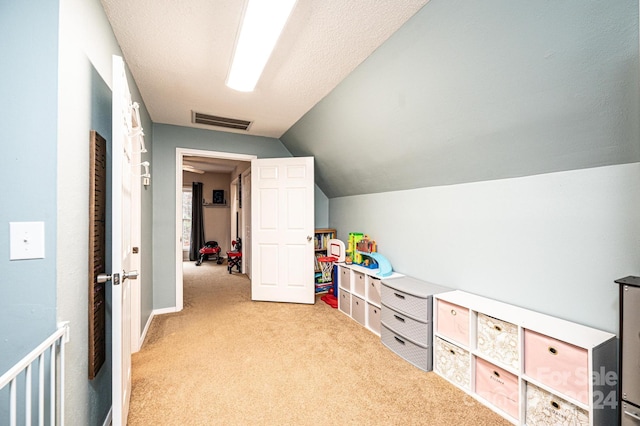 game room with a textured ceiling, light carpet, and vaulted ceiling