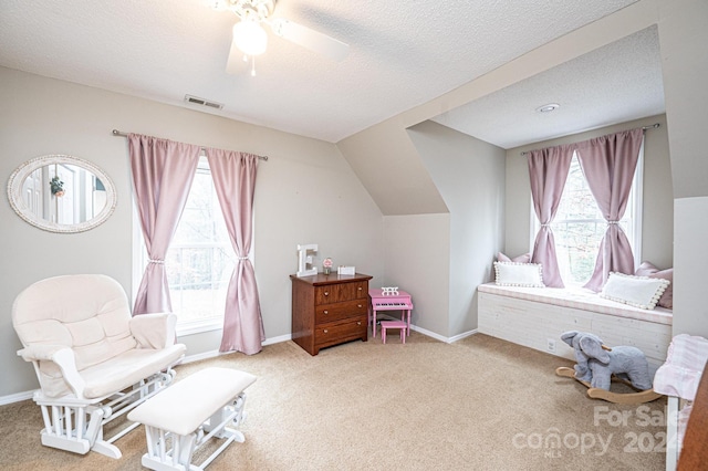 sitting room with a textured ceiling, carpet floors, and plenty of natural light