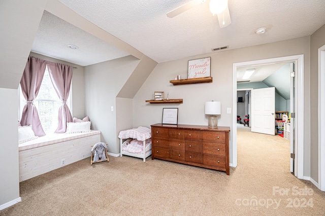 bedroom featuring ceiling fan, light colored carpet, lofted ceiling, and a textured ceiling