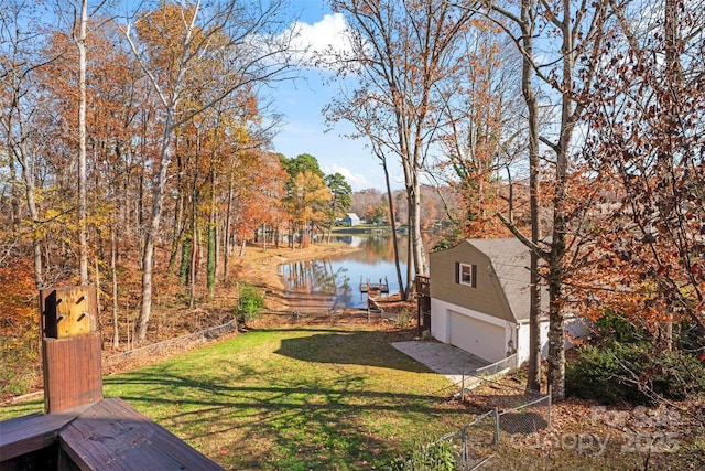 view of yard featuring a dock, a water view, and an outbuilding