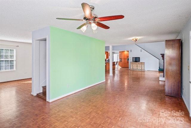 interior space featuring ceiling fan, parquet floors, and a textured ceiling