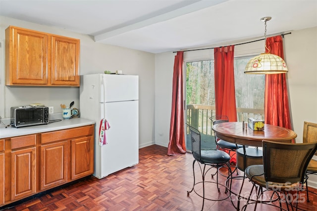 kitchen featuring decorative light fixtures, white refrigerator, and dark parquet floors