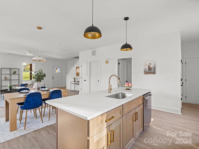 kitchen with sink, pendant lighting, a center island with sink, and light hardwood / wood-style flooring