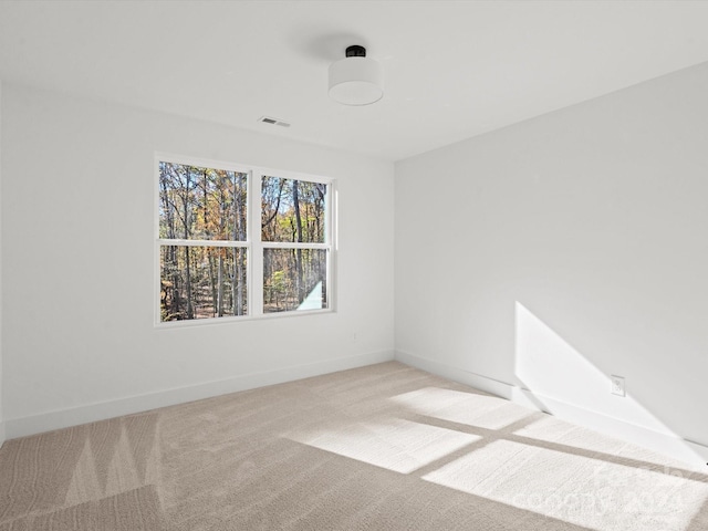 spare room featuring light colored carpet