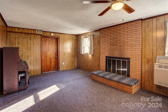 unfurnished living room with wooden walls, a fireplace, and dark carpet