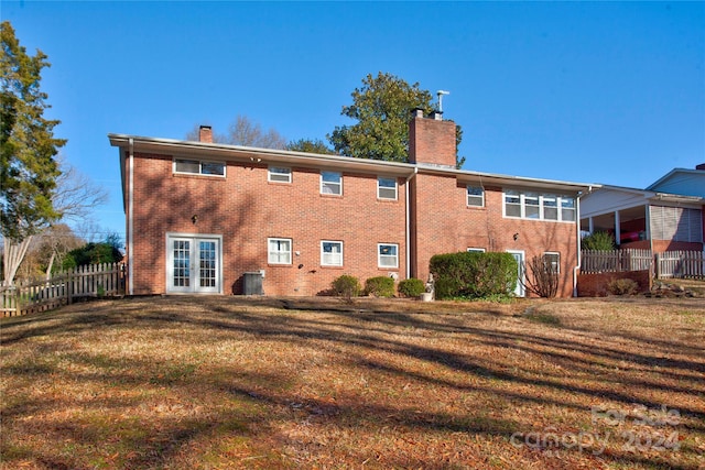 rear view of house featuring french doors and a yard