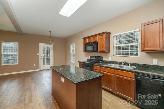 kitchen with light hardwood / wood-style flooring, sink, a kitchen island, and black appliances