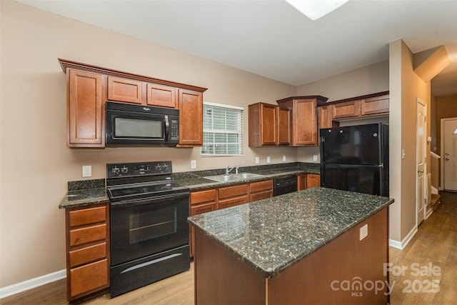 kitchen with a kitchen island, sink, light hardwood / wood-style floors, and black appliances