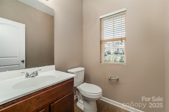 bathroom featuring vanity, wood-type flooring, and toilet