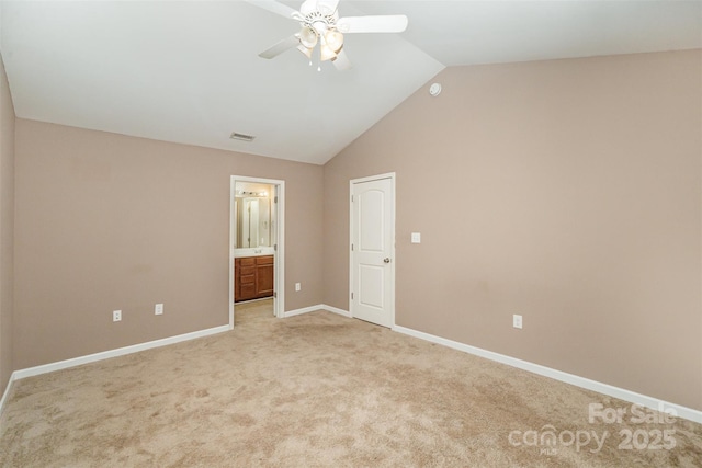 unfurnished bedroom featuring ceiling fan, lofted ceiling, light carpet, and ensuite bath